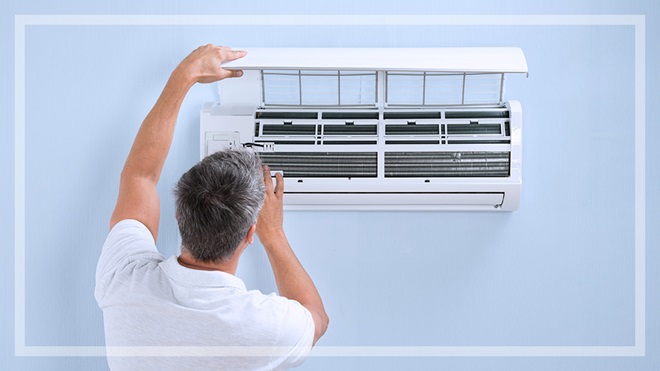 man looking at size of air conditioner on wall